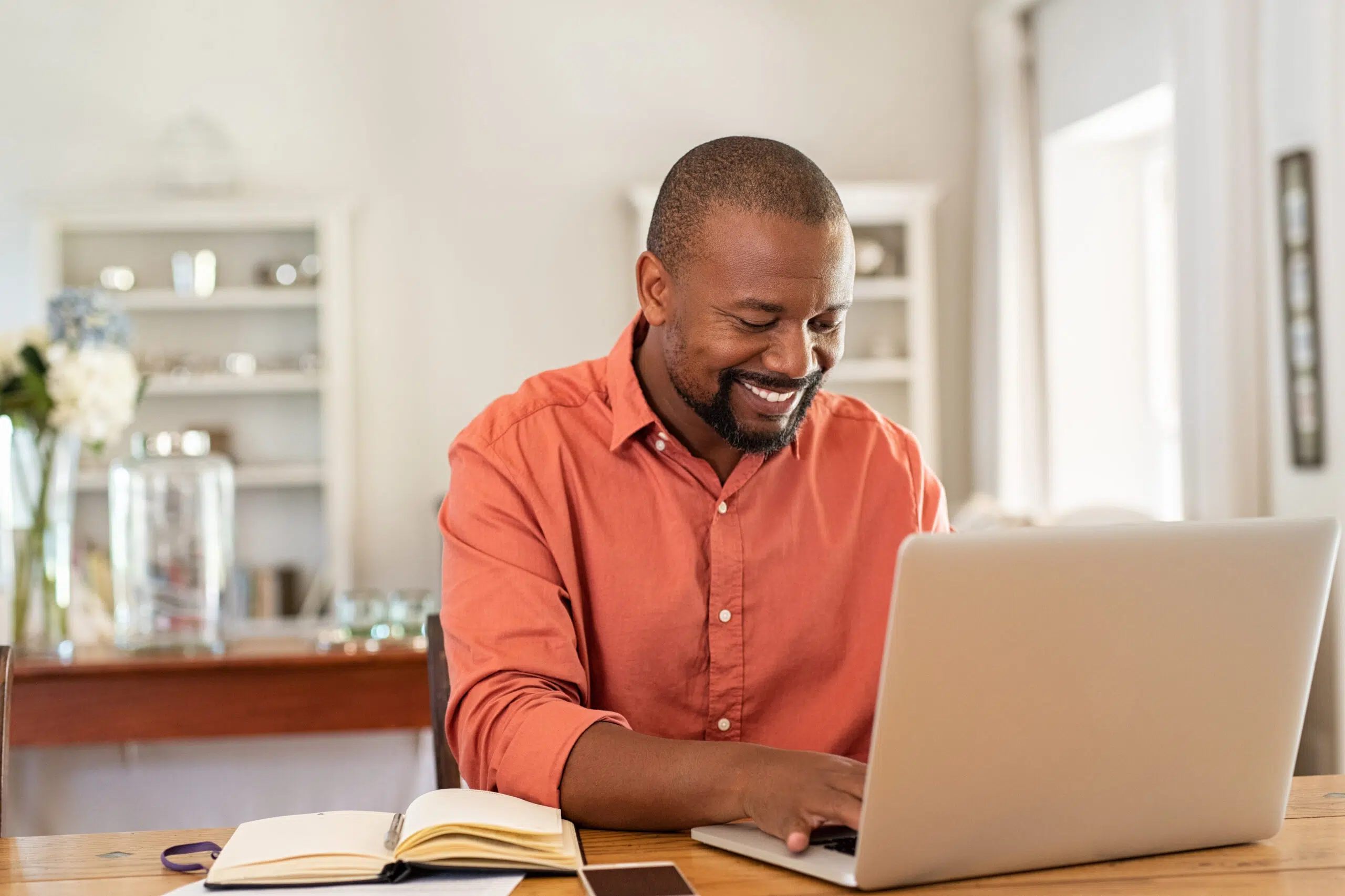 Smiling,Black,Man,Using,Laptop,At,Home,In,Living,Room.