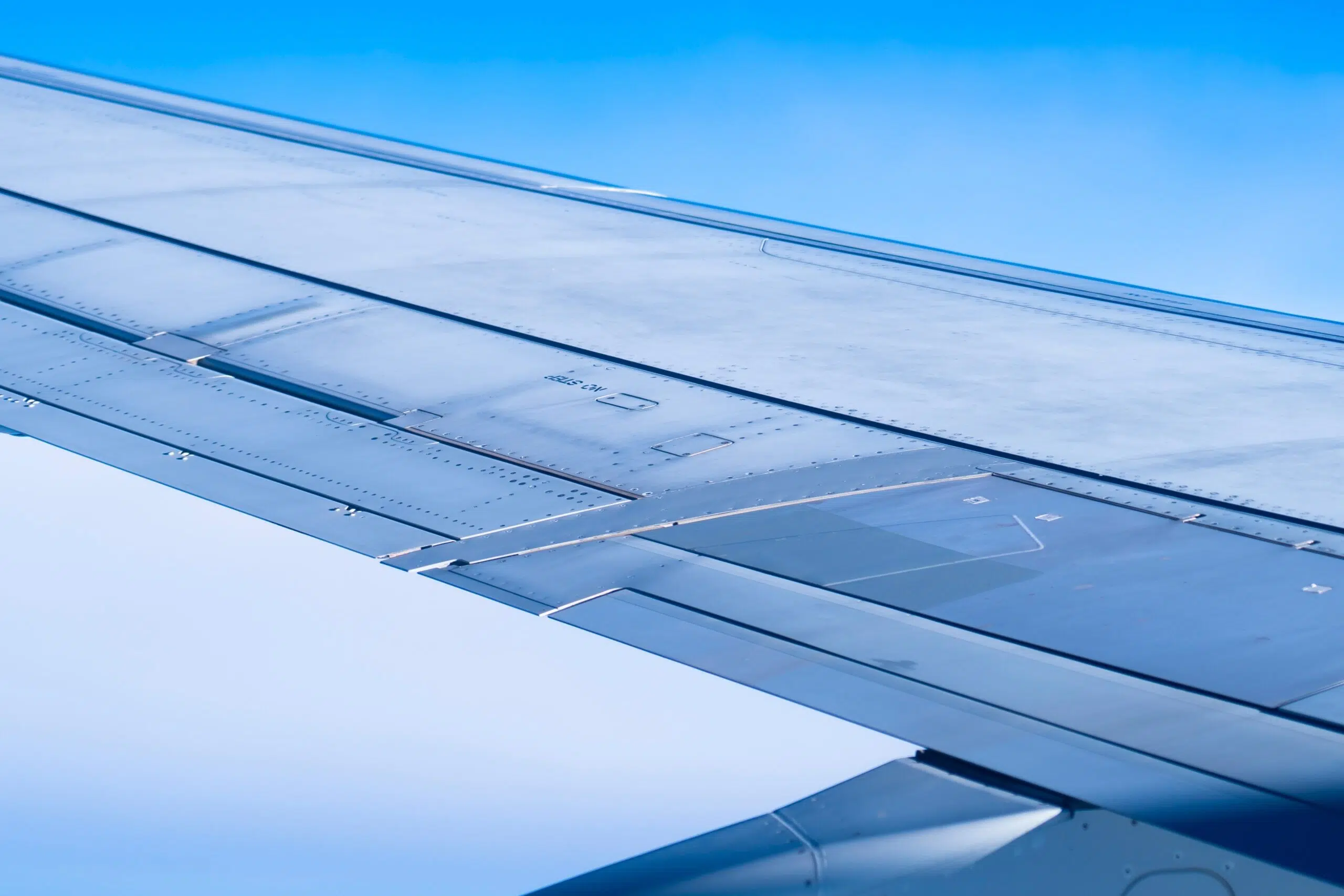 Wing,Of,Airplane,Flying,Above,Clouds.,Close,Up,Photo.